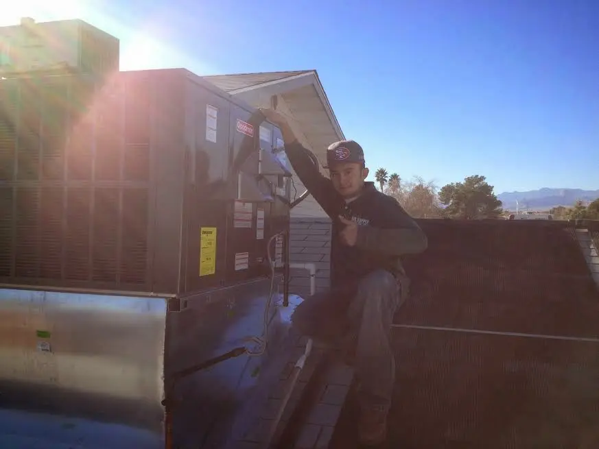 HVAC technician performing Air Duct Cleaning on a rooftop unit in Powell
